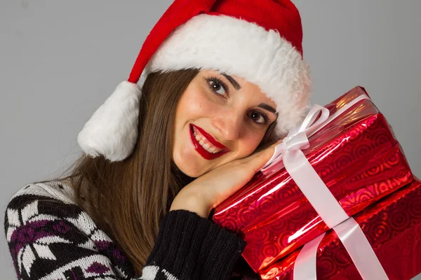 Donna in maglione caldo e cappello da Babbo Natale con regalo rosso — Foto Stock