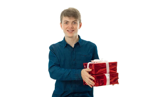 Beautiful young man with gifts in hands — Stock Photo, Image