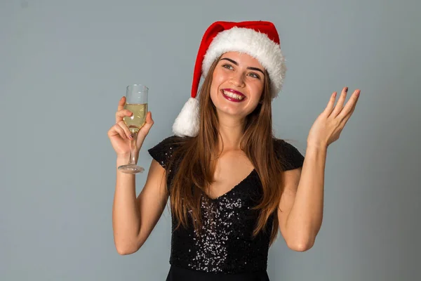 Modemädchen mit Weihnachtsmütze und einem Glas Champagner — Stockfoto