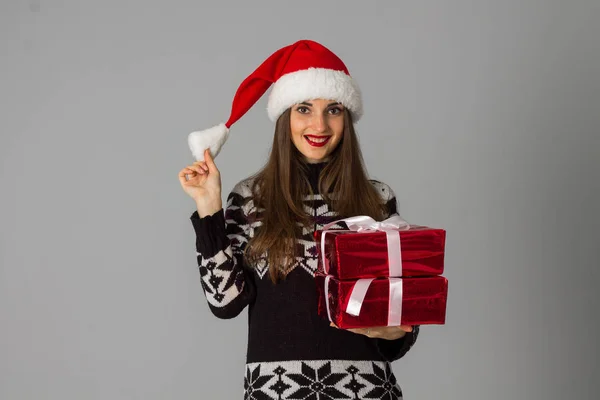 女人在温暖的毛衣和圣诞老人帽子红色礼物 — 图库照片