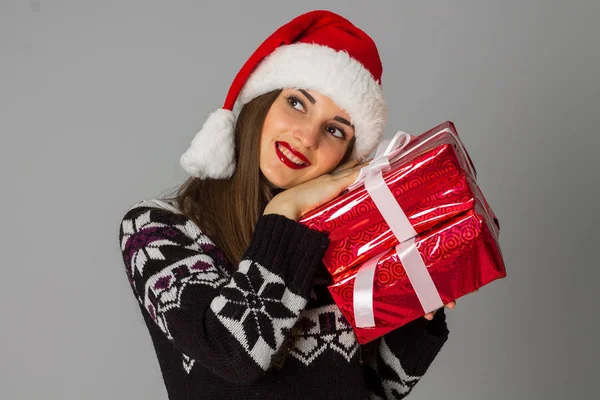 Frau in warmem Pullover und Weihnachtsmütze mit rotem Geschenk — Stockfoto