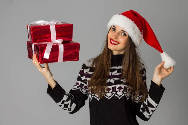 Donna in maglione caldo e cappello da Babbo Natale con regalo rosso — Foto Stock