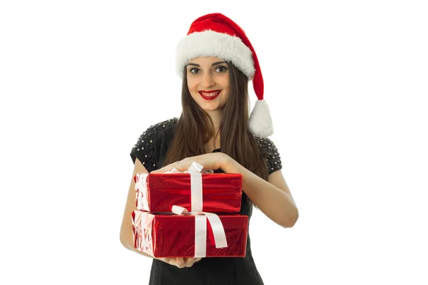 俊俏的姑娘，在圣诞老人的帽子与红色礼物 — 图库照片