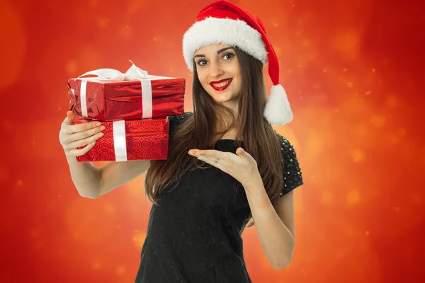 Ragazza allegra in cappello di Babbo Natale con regalo rosso — Foto Stock