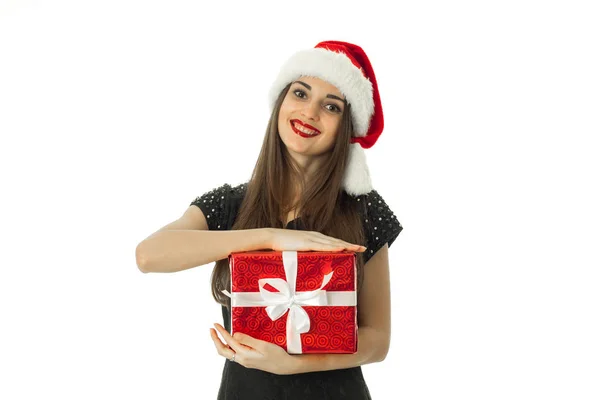 Ragazza alla moda in cappello di Babbo Natale con regalo rosso — Foto Stock