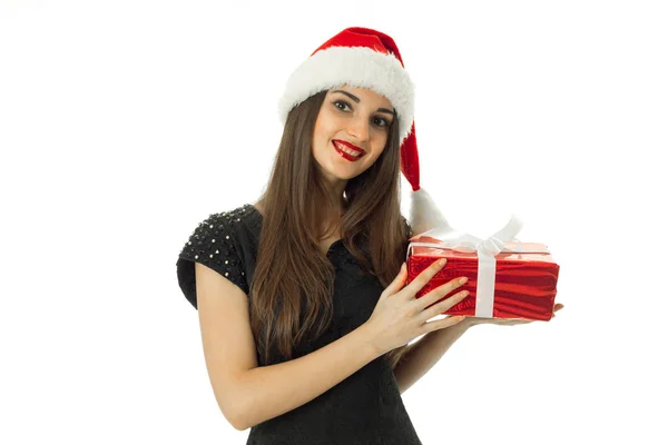 Young girl smiling in santa hat with red gift — Stock Photo, Image