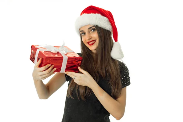 Chica de belleza sonriendo en sombrero de santa con regalo rojo — Foto de Stock