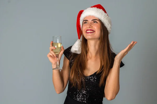 年轻的女孩，在圣诞老人的帽子杯香槟酒 — 图库照片