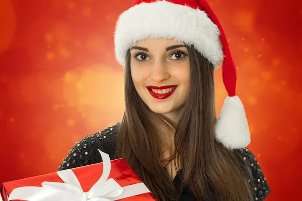Mädchen in Weihnachtsmütze mit roter Geschenkbox — Stockfoto