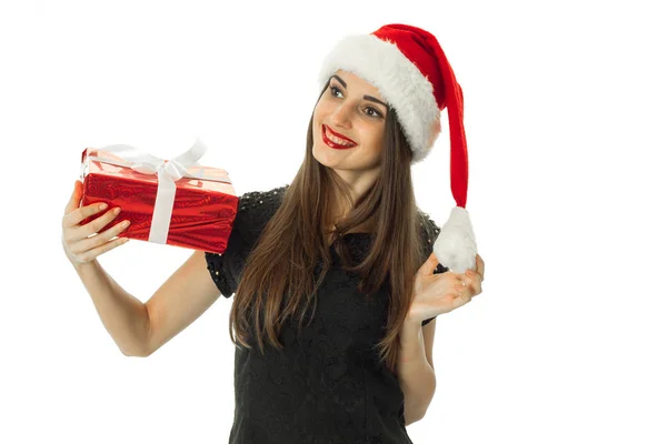 Adorable chica sonriendo en sombrero de santa con regalo rojo — Foto de Stock