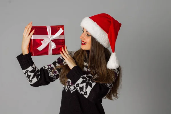 Donna in maglione caldo e cappello da Babbo Natale con regalo rosso — Foto Stock