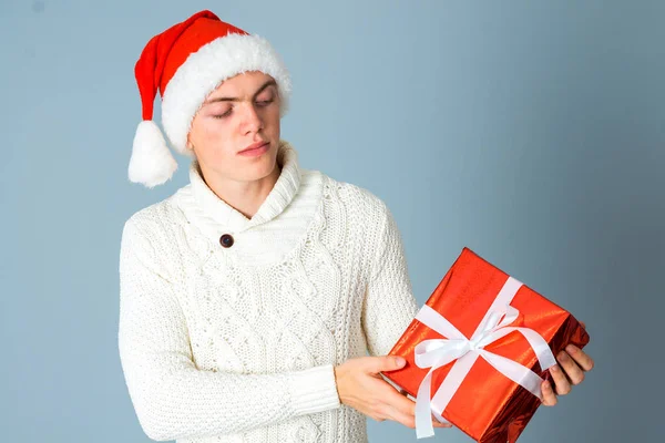 Ragazzo con regalo rosso in mano e con cappello di Babbo Natale — Foto Stock
