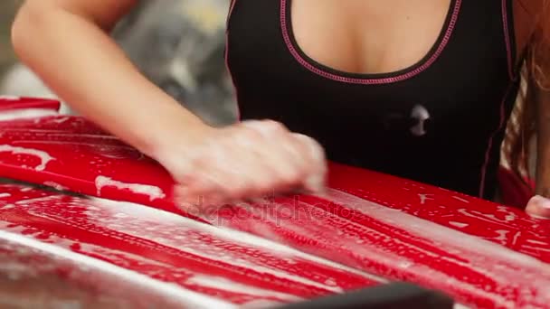 Chica joven lava un coche deportivo rojo — Vídeos de Stock