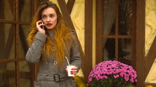 Ragazza che parla al telefono e tiene la tazza di caffè — Video Stock