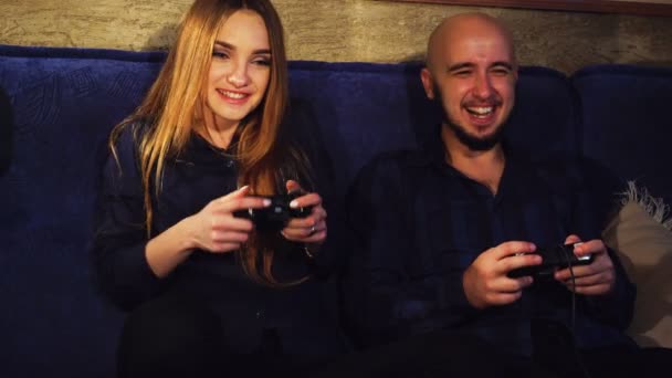 Menina engraçada e um cara estão jogando jogos de computador — Vídeo de Stock