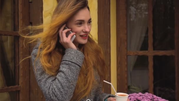 Девушка говорит и смеется по телефону — стоковое видео