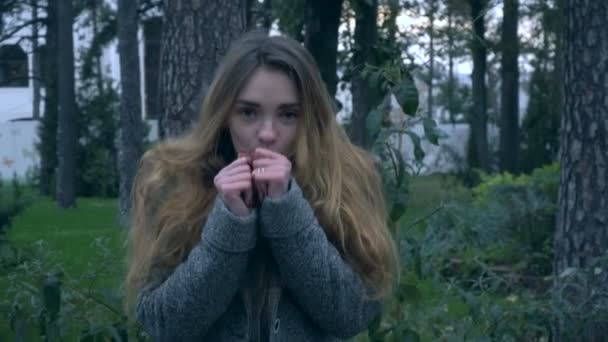 Девушка стоит на улице и замерзает от холода — стоковое видео