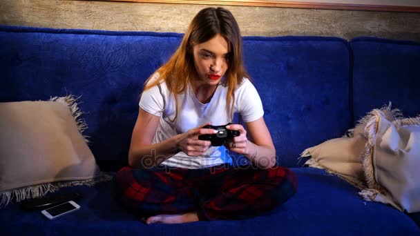 Дівчина сидить граючи в комп'ютерні ігри і розмови — стокове відео
