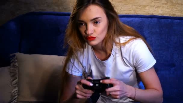 Meisje die een wit t-shirt zit en het spelen van computerspelletjes — Stockvideo
