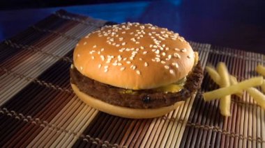 Burger masanın üzerine kızarmış patates ile yatıyor.