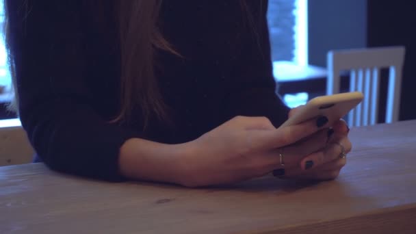 fille assise derrière le bureau et tenant un téléphone 