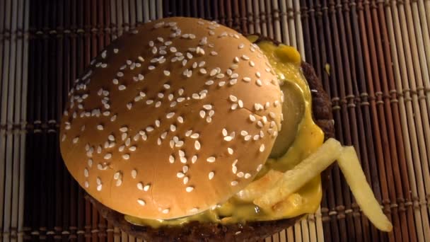 Papas fritas crujientes están cayendo en hamburguesa con queso — Vídeos de Stock