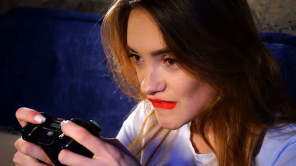 Chica con labios rojos sosteniendo un joystick y juega en un juego de ordenador — Vídeos de Stock