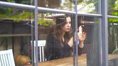 pencerenin oturan ve seyir telefon bir kız