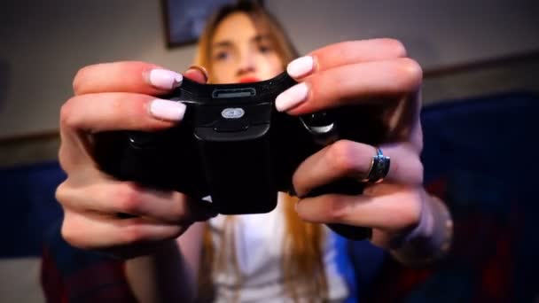 Девушка держит игровой джойстик и нажимает на кнопки — стоковое видео