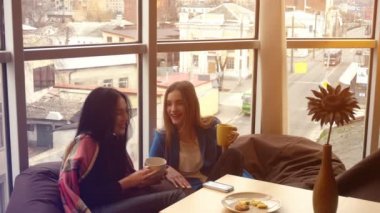 şirin kızlar koltuklarda oturup telefon bakmak