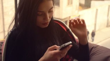 güzel siyah saçlı kız görünüyor telefon ve gülümseyen