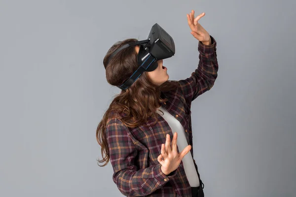 Atractiva mujer morena probando casco de realidad virtual — Foto de Stock