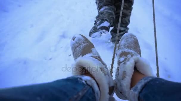 Man rolls a girl on a sled in the snow — Stock Video