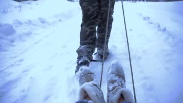 男人卷一个女孩在雪橇上 — 图库视频影像