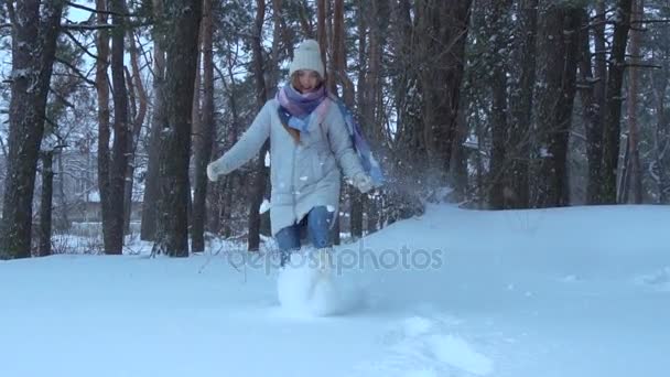 Menina feliz joga a neve com os pés — Vídeo de Stock