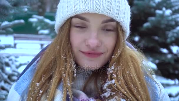 Menina bonito em um chapéu quente olha e sorri — Vídeo de Stock