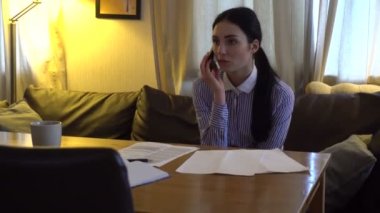 kanepede ve telefonda konuşurken esmer oturur