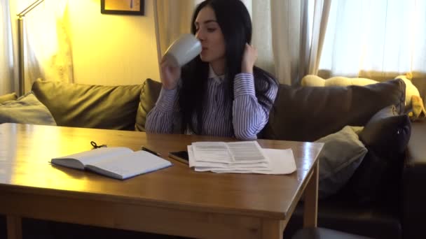 Menina bonita sentada no escritório, olhando para o papel e sorrindo — Vídeo de Stock