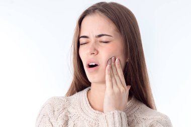 genç bir kız beyaz arka plan üzerinde izole yanağına el tutar