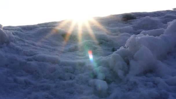 温暖的阳光照进冷白雪覆盖的山脉，在相机镜头 — 图库视频影像