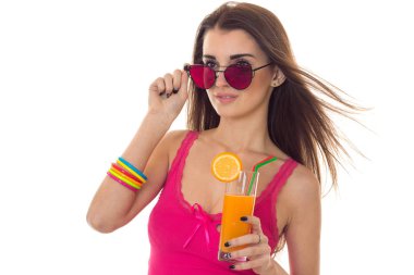 Yaz aylarında portresi beyaz arka plan üzerinde izole kokteyl elinde poz ile hafif giysiler ve güneş gözlüğü genç çekici kız