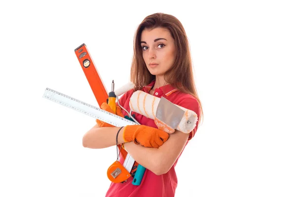 Joven encantador constructor chica en uniforme con un montón de herramientas hace la renovación aislada sobre fondo blanco — Foto de Stock