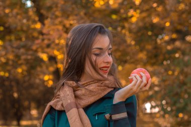 parkta bir eşarp ile güzel genç kız standları ve Apple el bakıyor