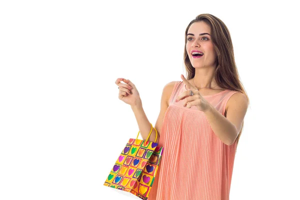 Una joven alegre muestra la mano hacia adelante y se mantiene en los otros paquetes diferentes sonriendo — Foto de Stock