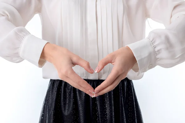 Dziewczyna w białej bluzce gospodarstwa ręce w przód i pokazuje palce serca — Zdjęcie stockowe