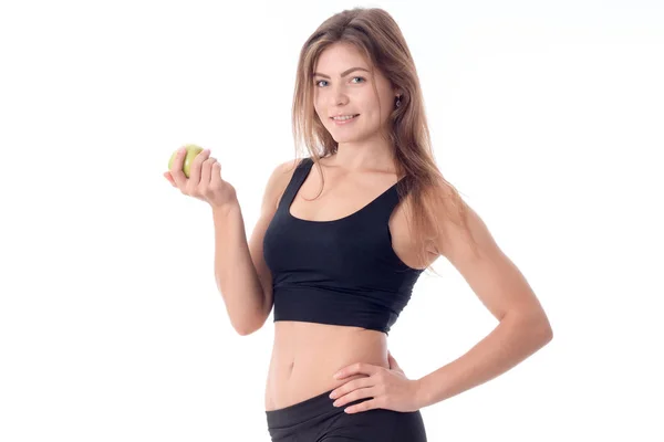 Mooi meisje glimlachend permanent opzij kijkt naar de afstand en het houden van een appel — Stockfoto