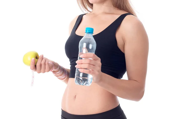 Gros plan de la fille sportive qui est tourné de côté et montre une pomme — Photo