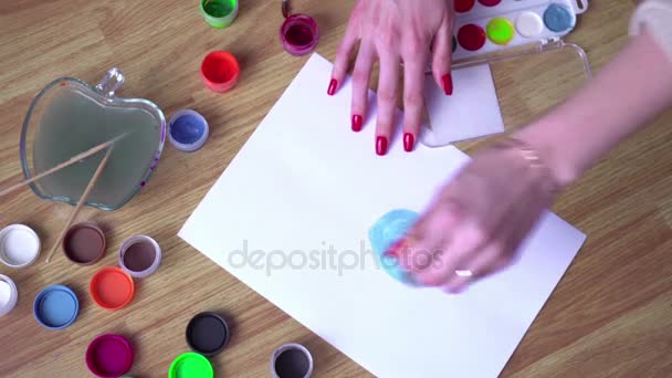 Девушка рисует яркие гуашь на бумаге — стоковое видео