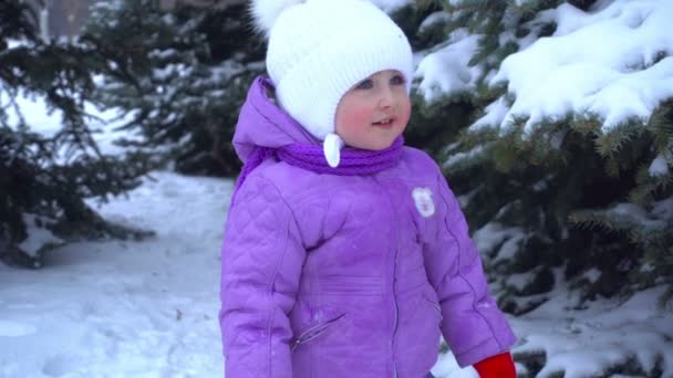 Kleines Mädchen steht im Winter auf der Straße neben Weihnachtsbäumen — Stockvideo