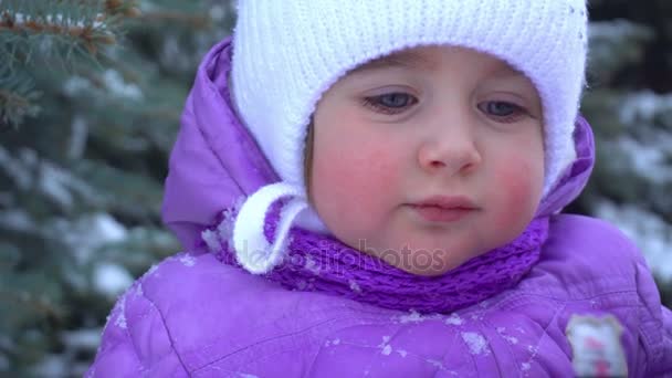 El niño pequeño está parado en la calle en el invierno y sonríe — Vídeos de Stock